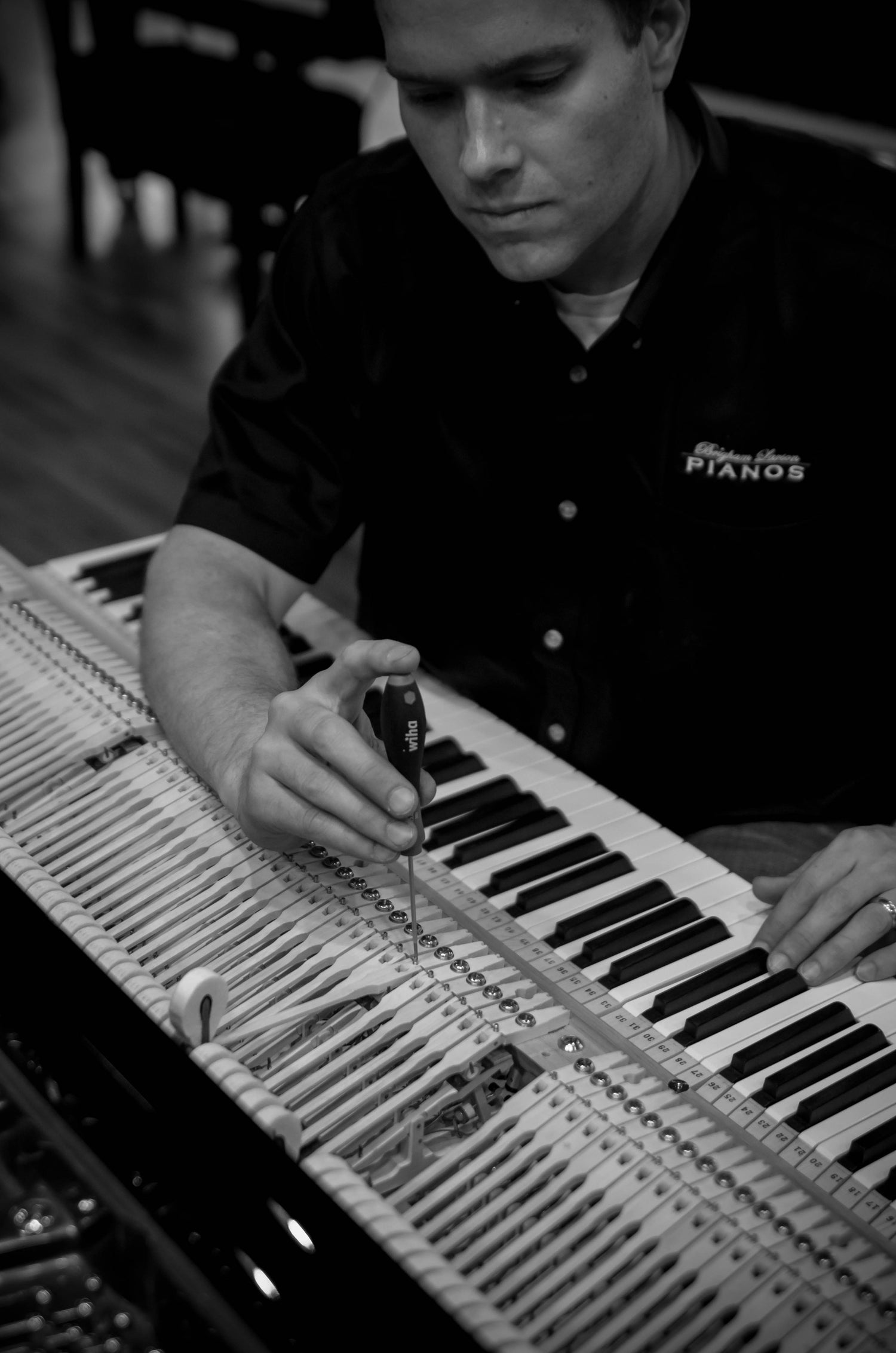 Brigham Larson working on a piano action grand piano
