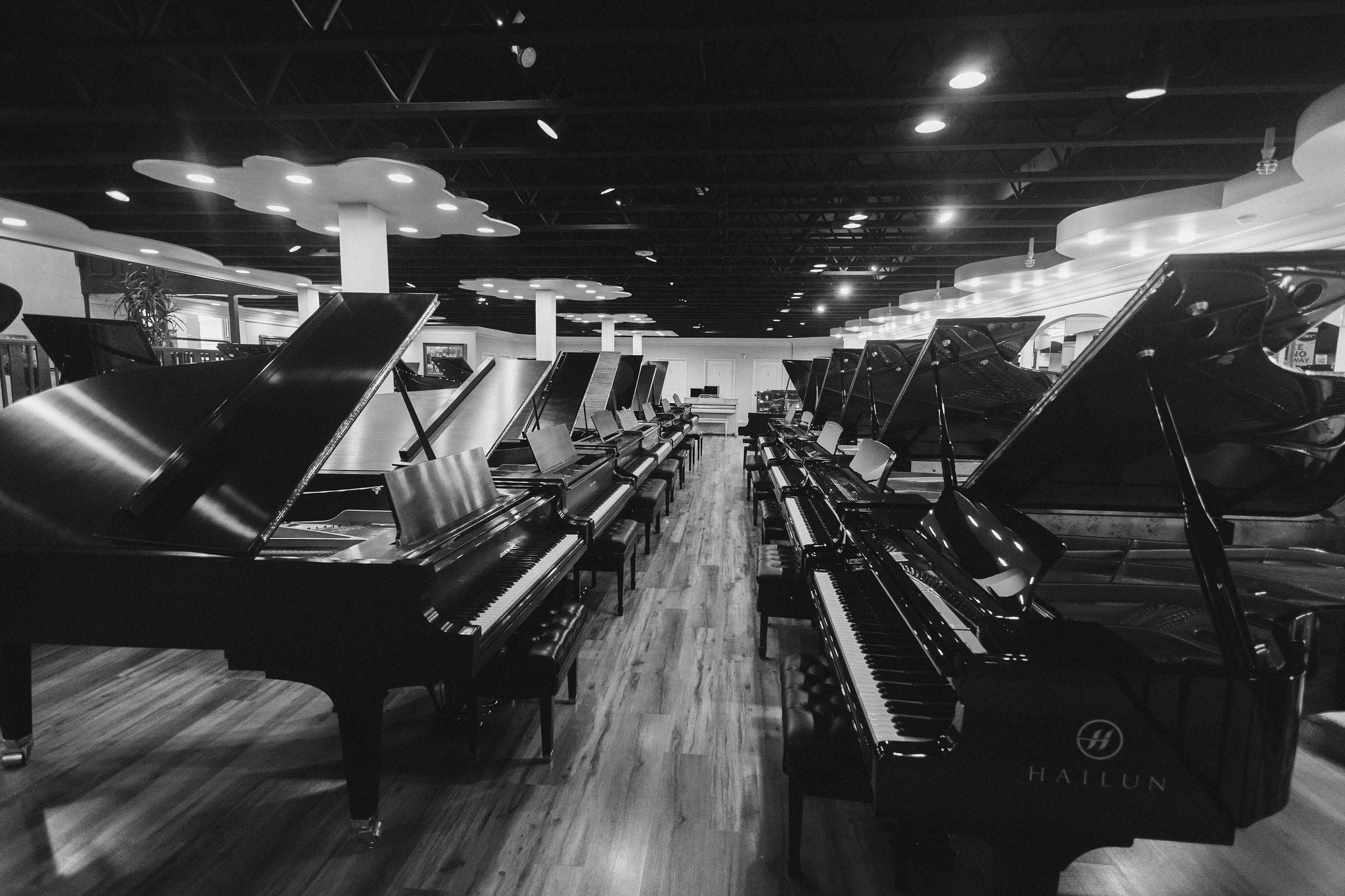 Brigham Larson Pianos Piano showroom with multiple rows of brand new Hailun and Hallet Davis grand and upright pianos as well as fully restored, refurbished and refinished Yamaha, Kawai, Baldwin, Mason & Hamlin and Steinway pianos on display and for sale in Orem, Utah.