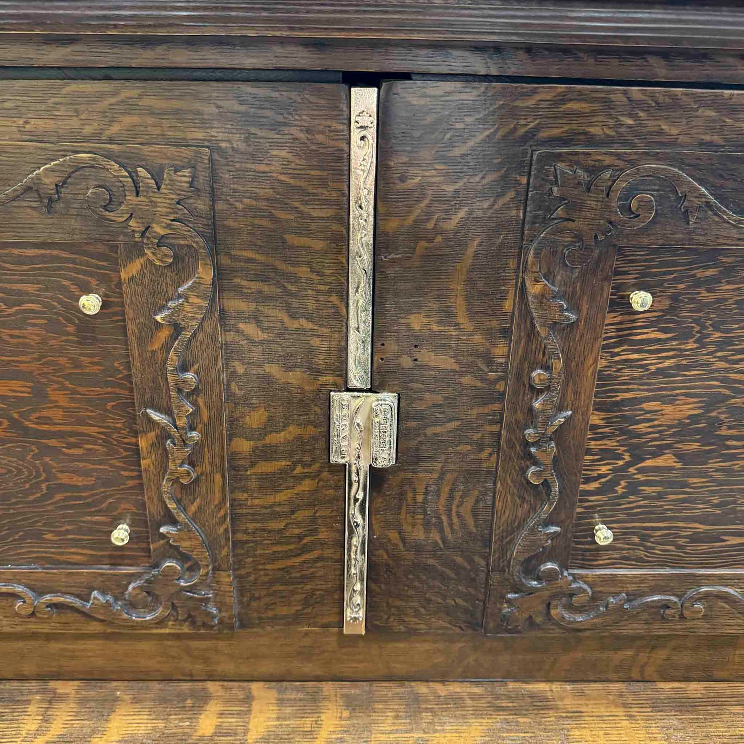 Close-up of a refinished wooden piano cabinet with decorative hinges and carvings designed with CAD, and 3D printed, then electroplated with shiny brass at Brigham Larson Pianos in Orem, Utah piano heirloom piano restoration shop.