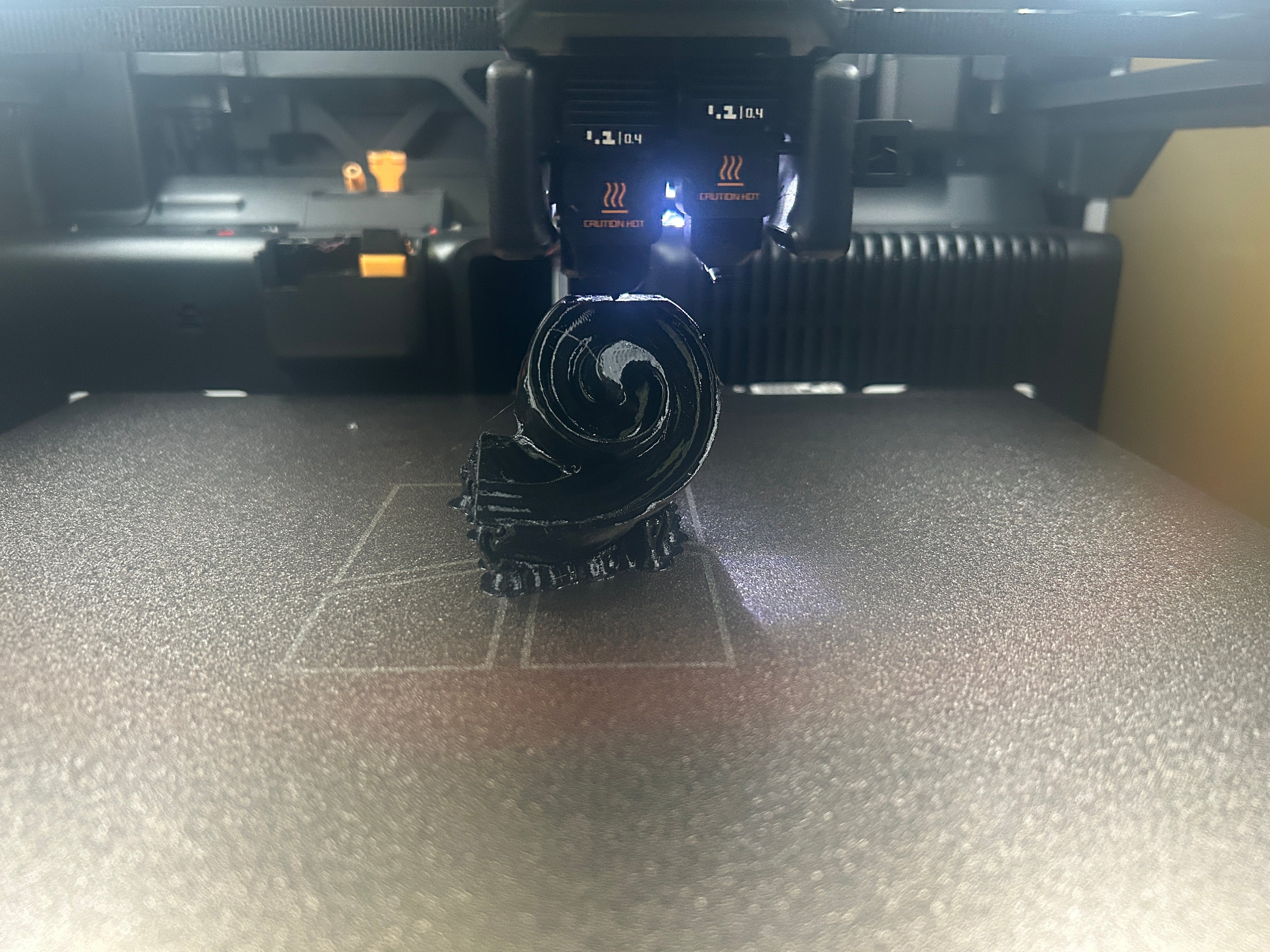 3D printer in operation with filament on a bed