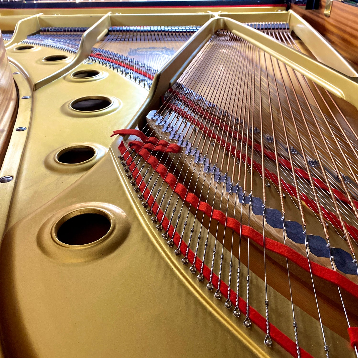 Close-up of a Yamaha C series grand piano's strings and soundboard