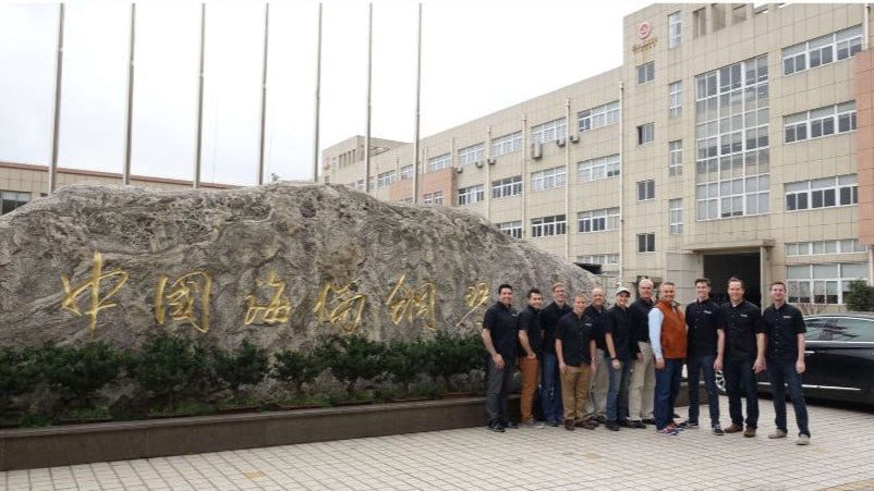 Photo of Brigham Larson and expert team of piano restoration artisans standing in a row in front of the Hailun Piano factory, visiting Ningbo, the home of Hailun Pianos in China.