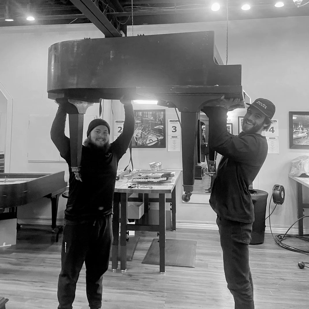 Grand and Upright Piano Moving services at Brigham Larson Pianos. Two skilled expert piano movers holding a grand piano.