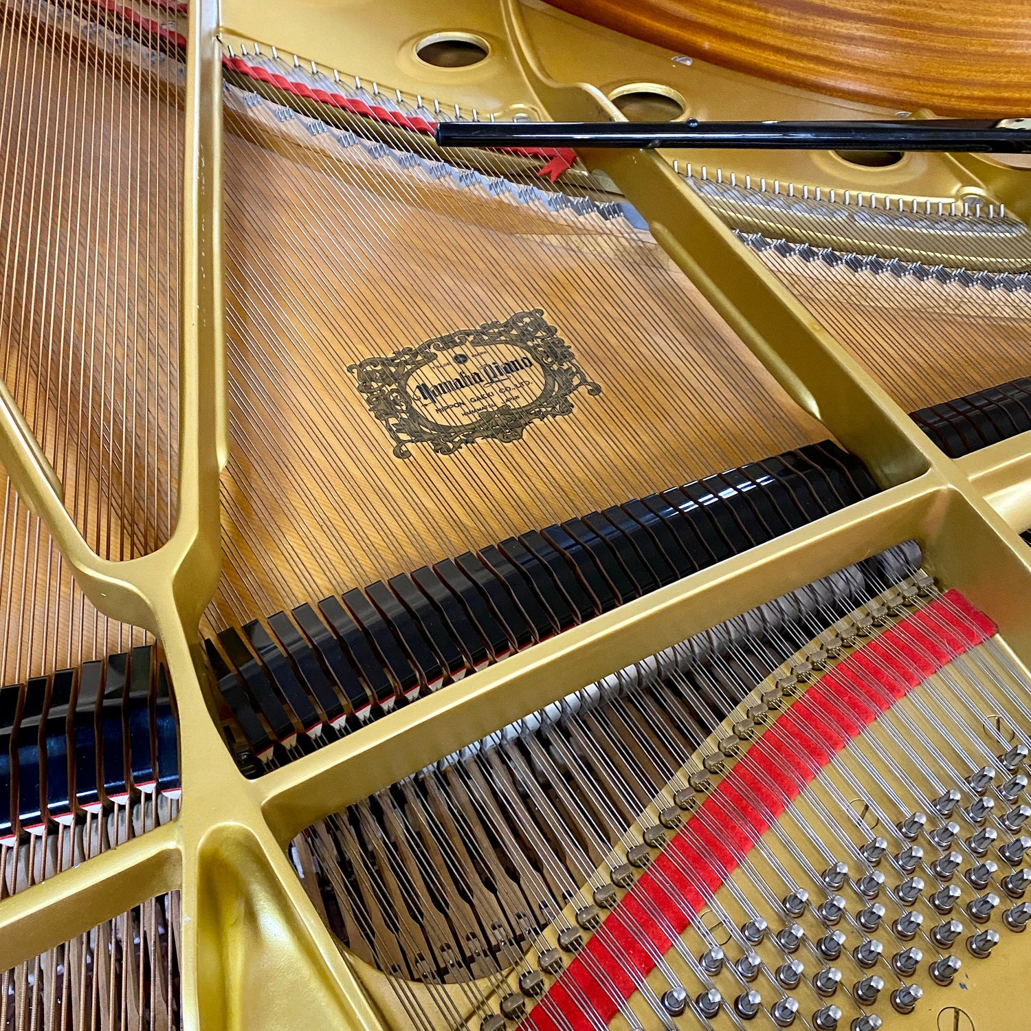1986 Yamaha C7 grand piano internal components like strings and hammers, and plate.